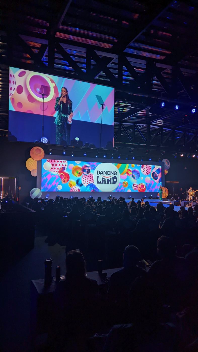 Palco do evento Danone Land com apresentadora e telão de LED
